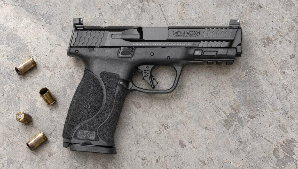 Smith & Wesson M&P9 M2.0 Optics Ready Full Size pistol with 4.25 inch barrel lying flat on a concrete shooting bench