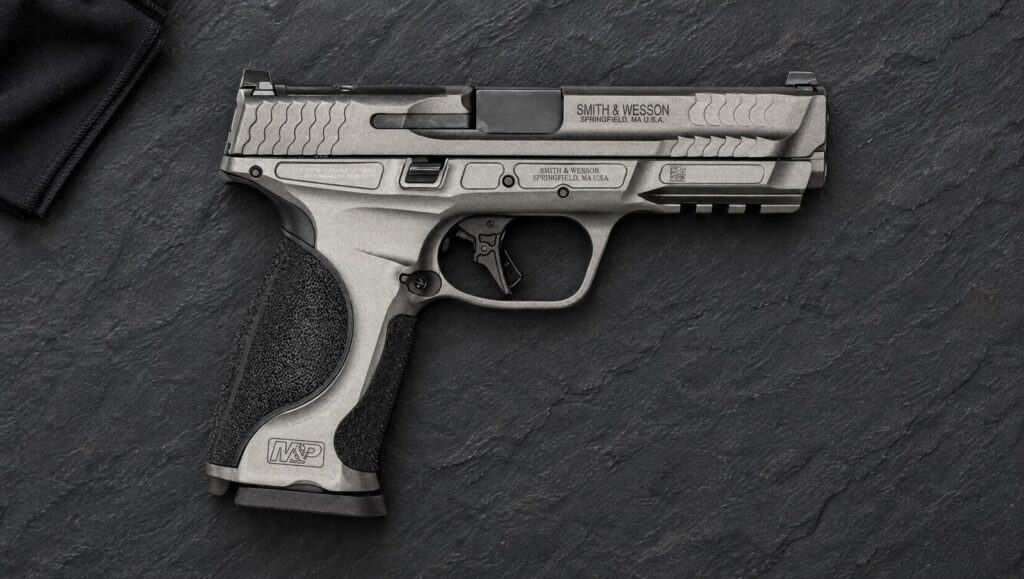 Smith & Wesson M&P9 M2.0 Metal pistol with Tungsten Gray aluminum frame lying flat on dark slate
