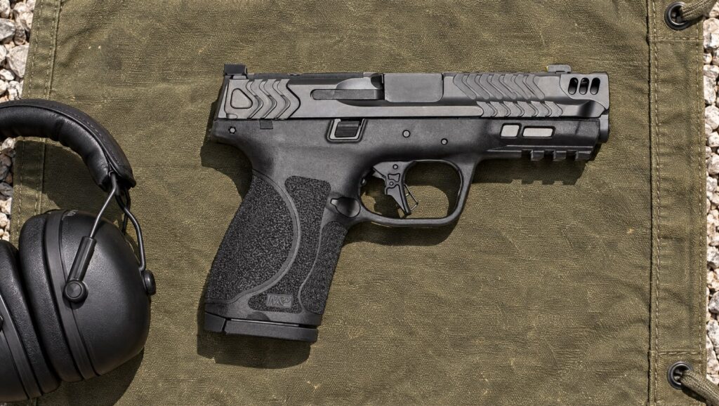 Smith & Wesson Performance Center M&P9 M2.0 Compact Carry Comp pistol with ported slide lying flat on an olive canvas range mat