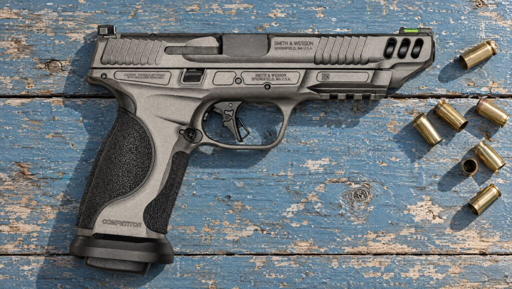 Smith & Wesson Performance Center M&P9 M2.0 Competitor pistol with 5 inch barrel and flared magwell lying flat on a blue wooden table