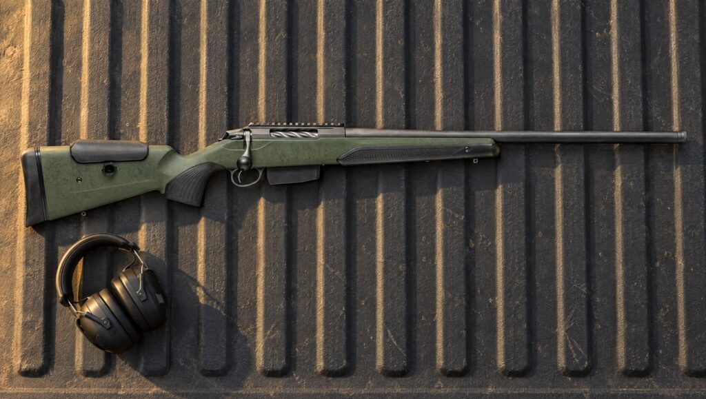 Tikka T3x Super Varmint with green Roughtech stock, Tungsten Cerakote heavy barrel and Picatinny rail lying flat in a truck bed