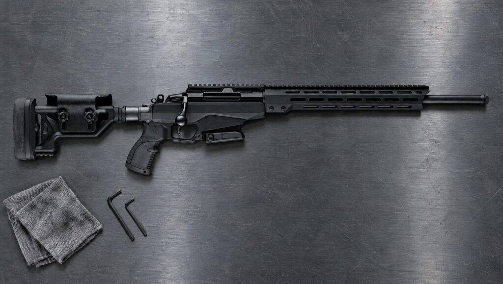 Tikka T3x TAC A1 in black folding aluminum chassis with full-length Picatinny rail lying flat on a steel workbench