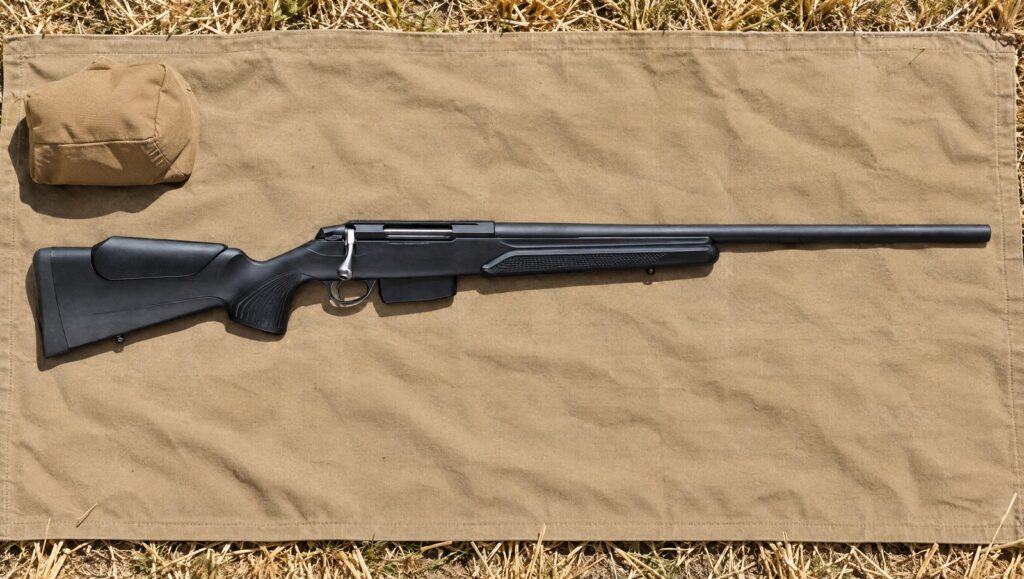 Tikka T3x Varmint with heavy barrel, vertical grip and wide forend lying flat on a canvas shooting mat