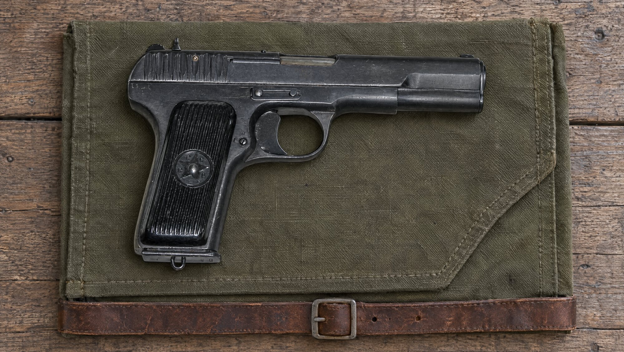 Soviet Tokarev TT-33 pistol in 7.62x25 lying on an olive canvas map case