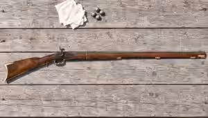 Traditions Kentucky percussion rifle lying flat on a sun-bleached wooden shooting bench with patches and lead balls