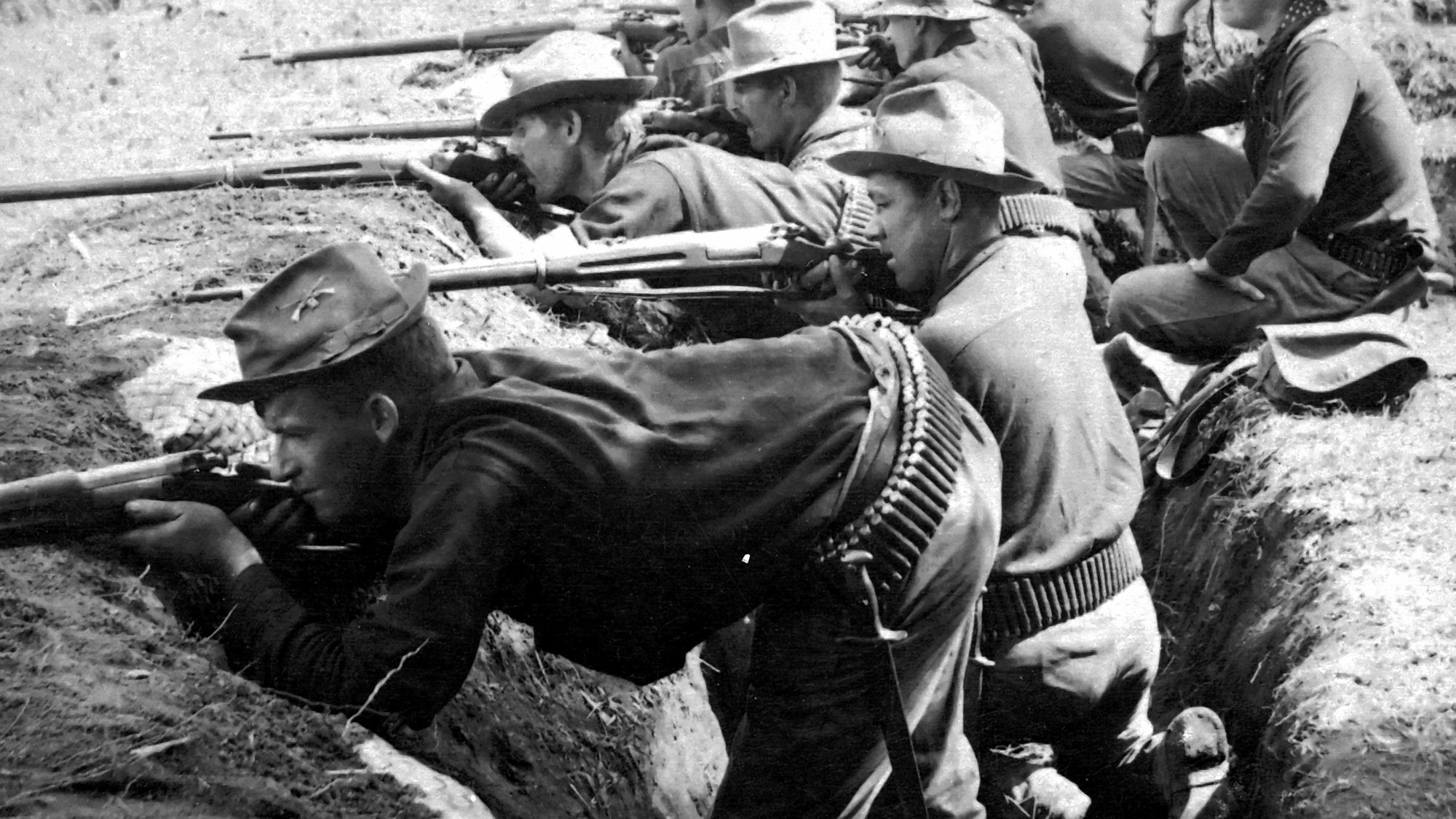 US soldiers firing Krag-Jorgensen rifles from a trench in the Philippines in 1899