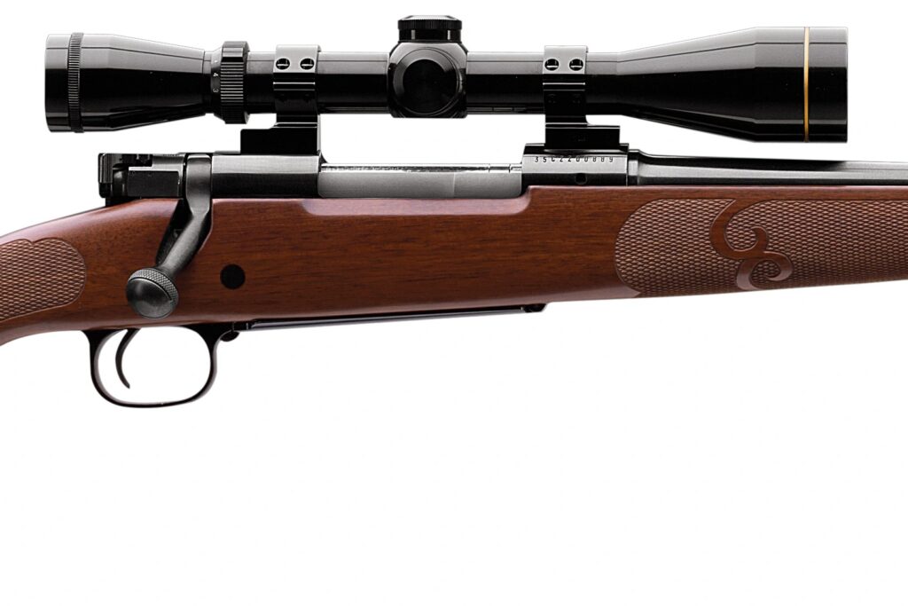 Winchester Model 70 Featherweight action close-up showing the bolt handle, the three-position safety on the bolt shroud, the claw extractor along the bolt and a scope in rings